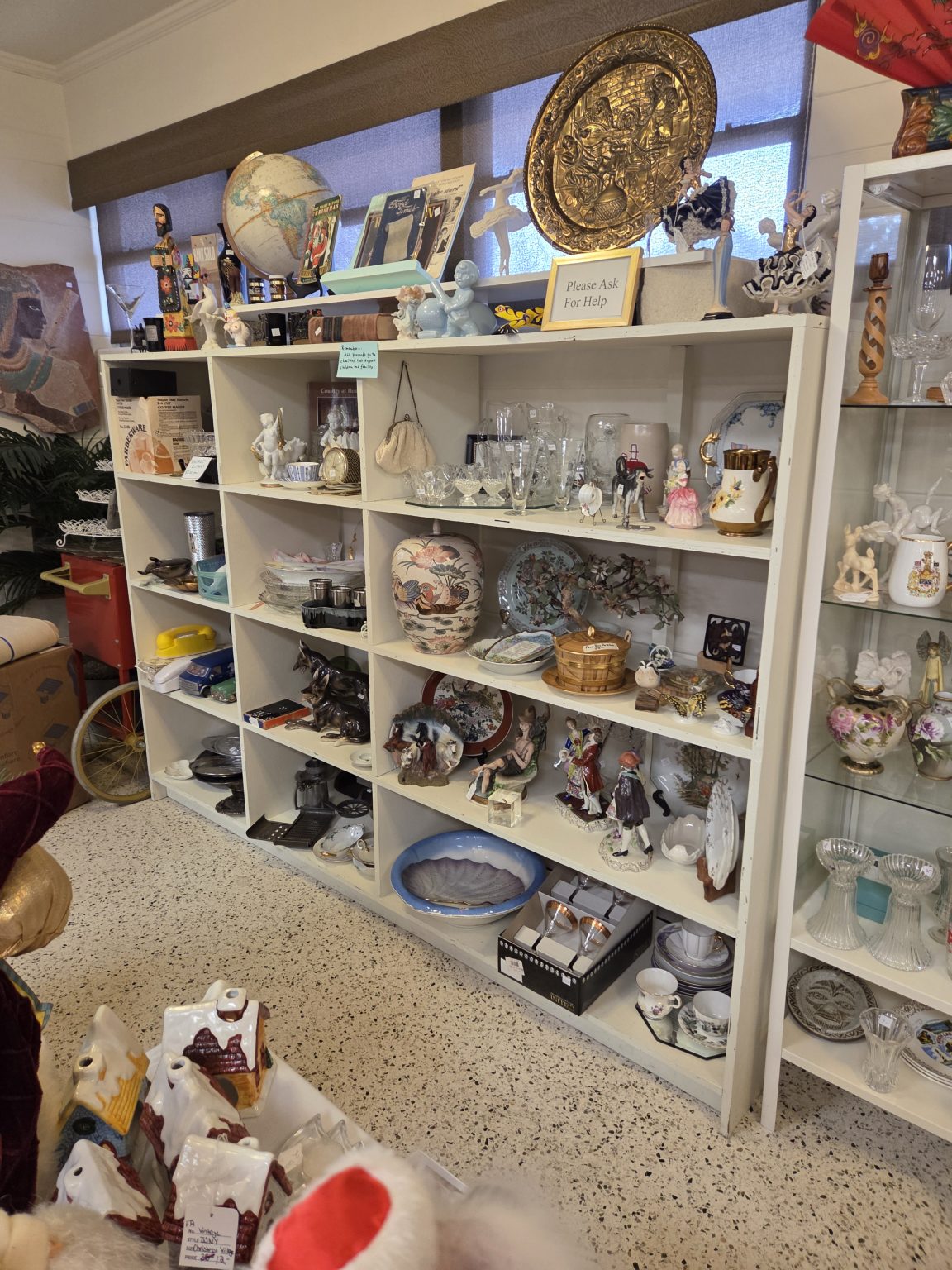 Shelf of donated fine china, crystal and collectibles at the Winter Park Benefit Shop